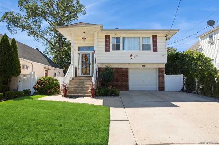 View of front of house featuring brick siding, driveway, and a garage