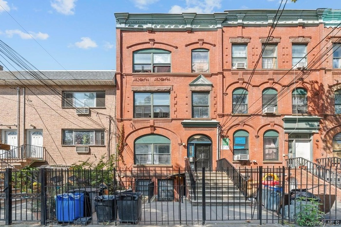 Italianate-style house with brick siding and a fenced front yard