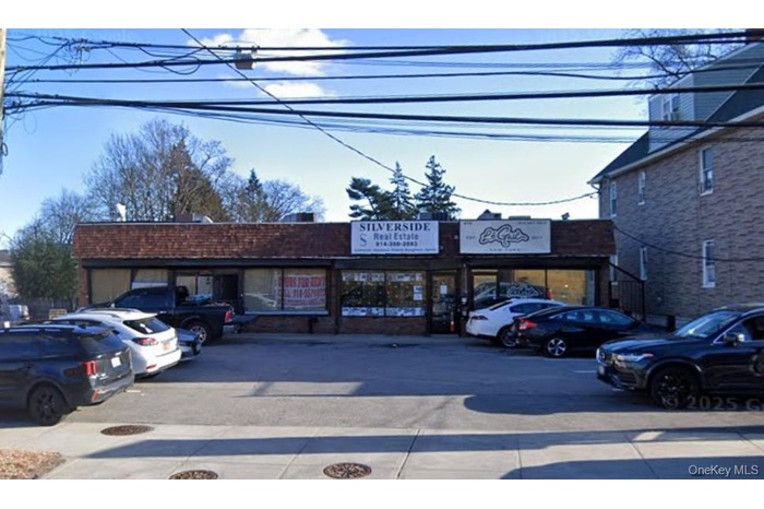 View of commercial property featuring uncovered parking