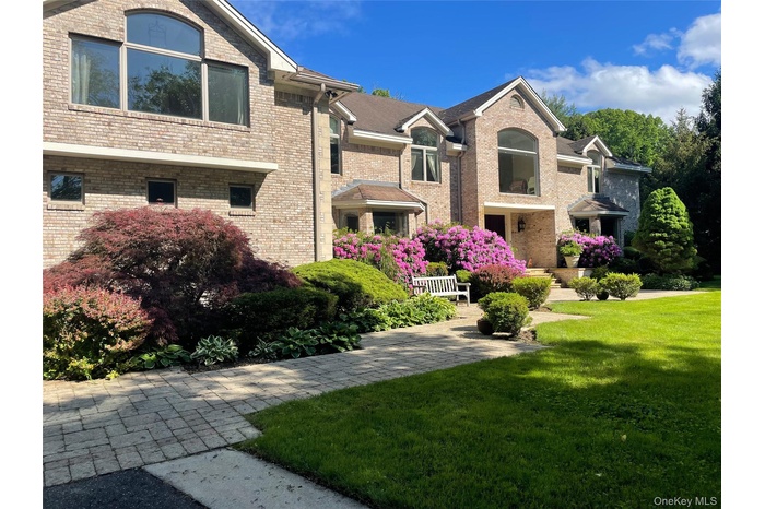 Front of colonial-style brick home, pavered walkway