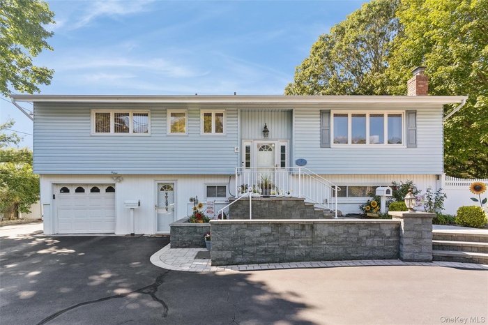 Hi Ranch home with asphalt driveway and an attached garage