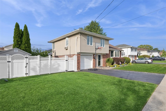 View of home's exterior featuring a gate, brick siding, asphalt driveway, and a garage