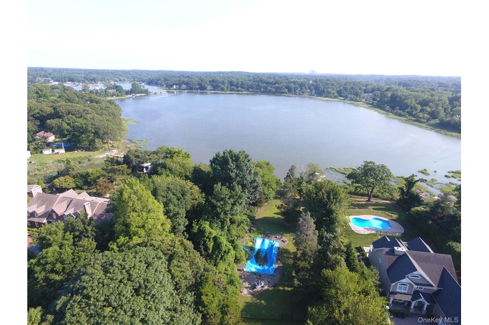Aerial view of a nearby body of water and a heavily wooded area