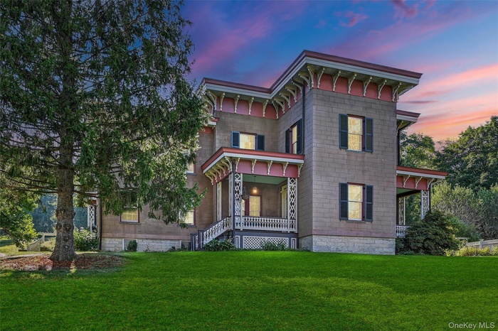 Italianate house with covered porches and manicured grounds