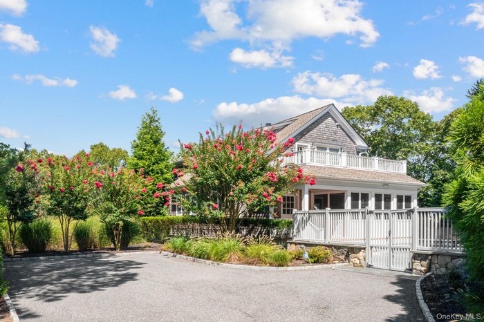 View of front of house with a gate, a balcony, and driveway
