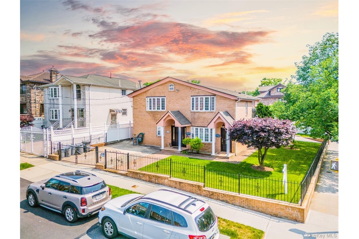Traditional-style house featuring a fenced front yard and brick siding
