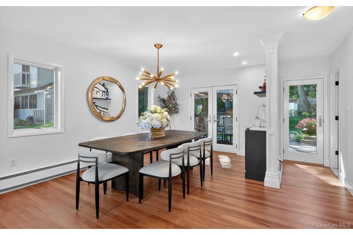 Dining space with french doors, light wood finished floors, a chandelier, recessed lighting