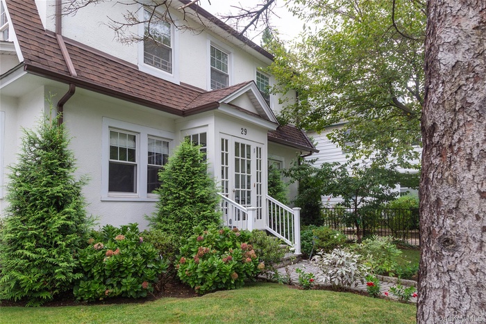 View of side of home with stucco siding and a shingled roof