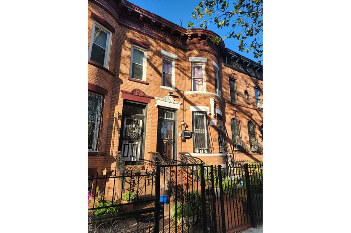 Italianate house featuring a fenced front yard and brick siding