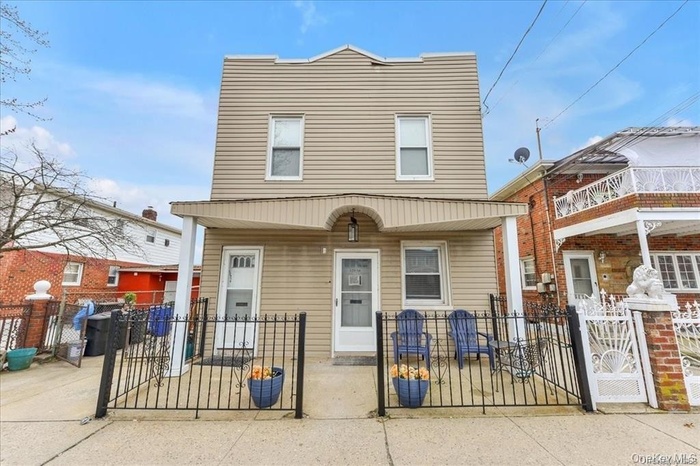 View of front of property with a gate, a fenced front yard, and a patio