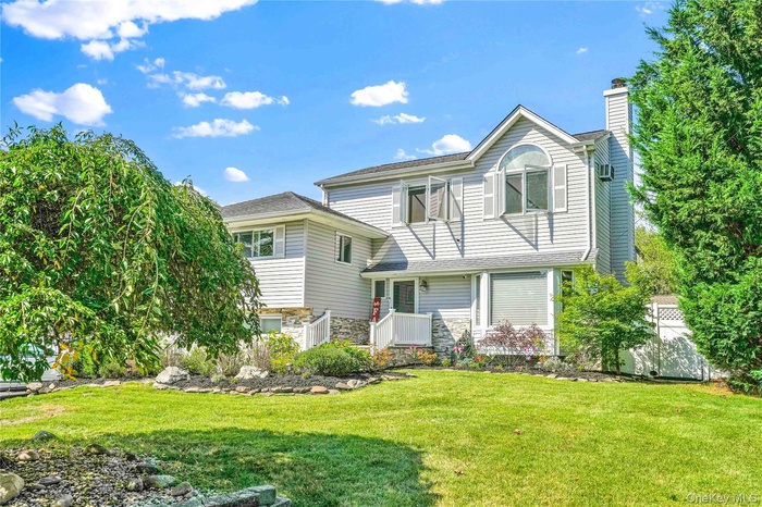 View of front of property with stone siding and a chimney