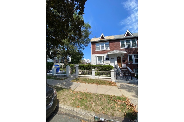 View of front of property featuring brick siding, a fenced front yard, a gate, and covered porch