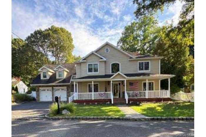 View of front of property featuring covered porch, a front lawn, and asphalt driveway