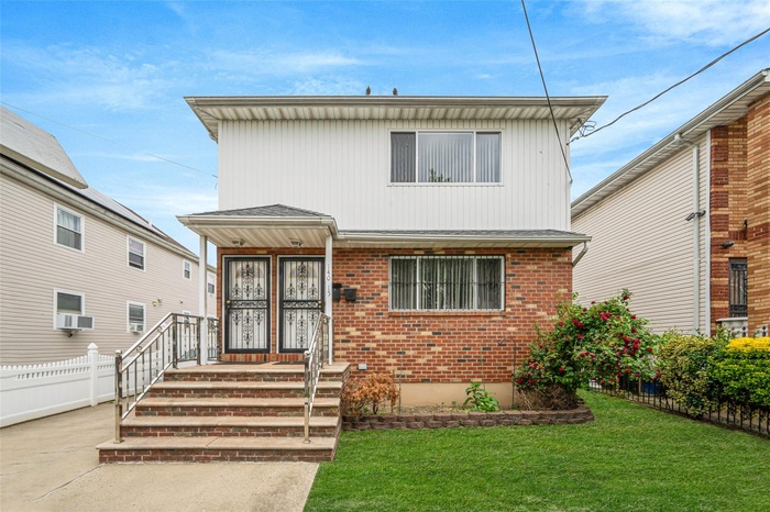 View of front of house with brick siding and cooling unit