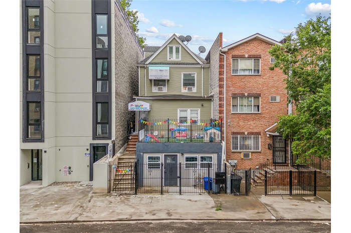 View of property with a fenced front yard and stairs