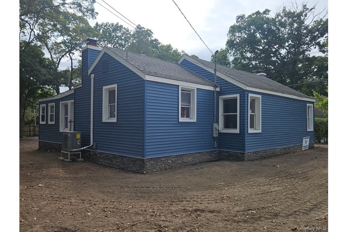 View of side of property featuring a chimney and a shingled roof