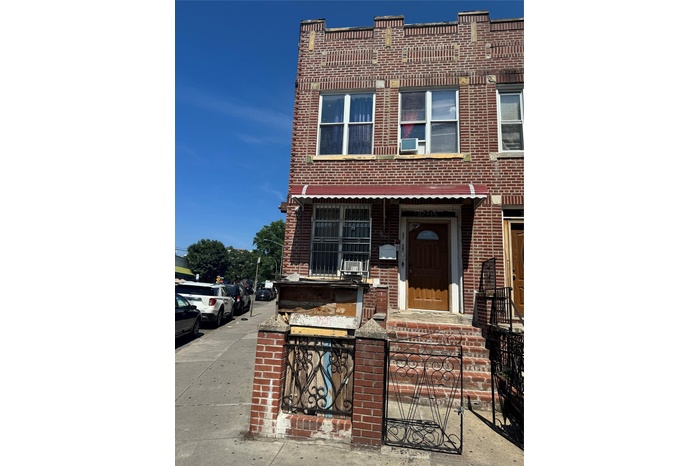 View of property with brick siding and cooling unit