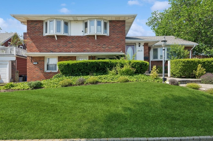 View of front facade with brick siding and a front yard