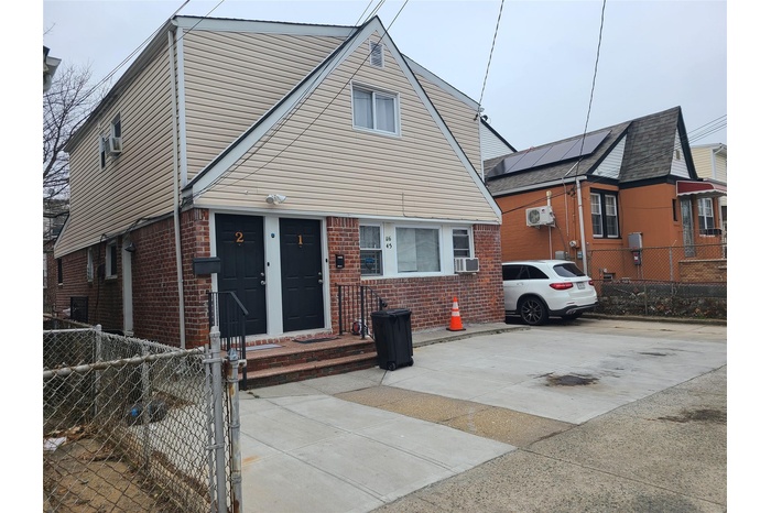 View of front of house with cooling unit, brick siding, and fence private yard