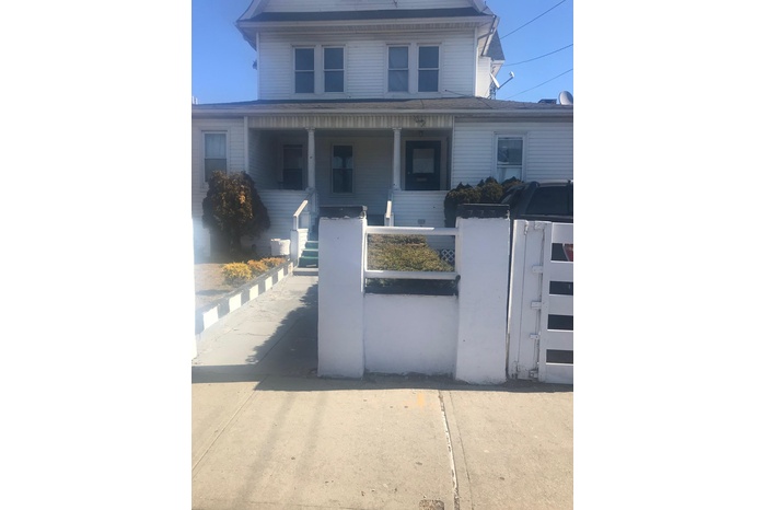 View of front of property with a gate, a fenced front yard, and a porch