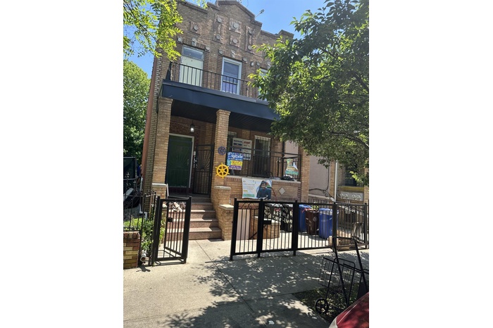 View of front of home with brick siding and a gate