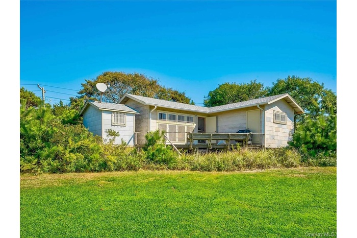 Rear view of property featuring a yard and a deck
