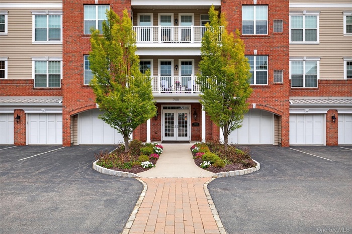 View of front of house with french doors, driveway, brick siding, and a garage