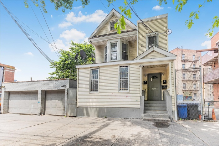 View of front facade with concrete driveway and a garage