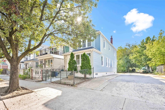 View of front of home featuring a chimney, a fenced front yard, and driveway