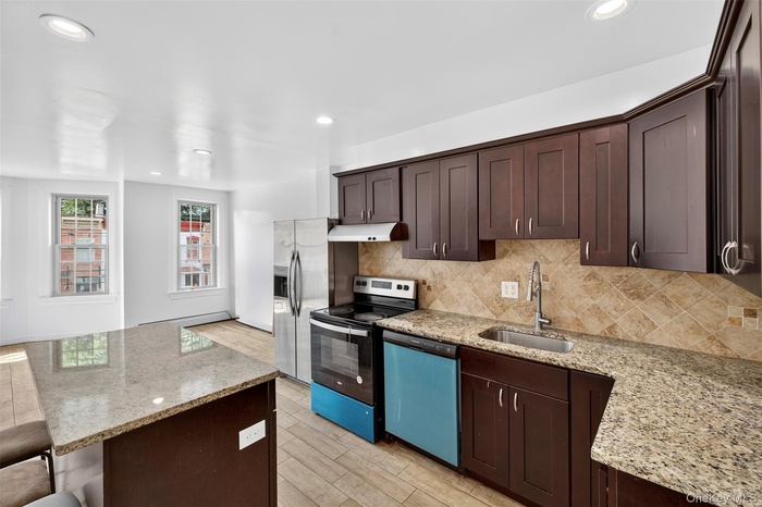 Kitchen featuring dark brown cabinetry, light stone countertops, electric stove, recessed lighting, and dishwashing machine