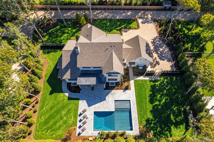 View of pool, stone patio and custom landscape package.