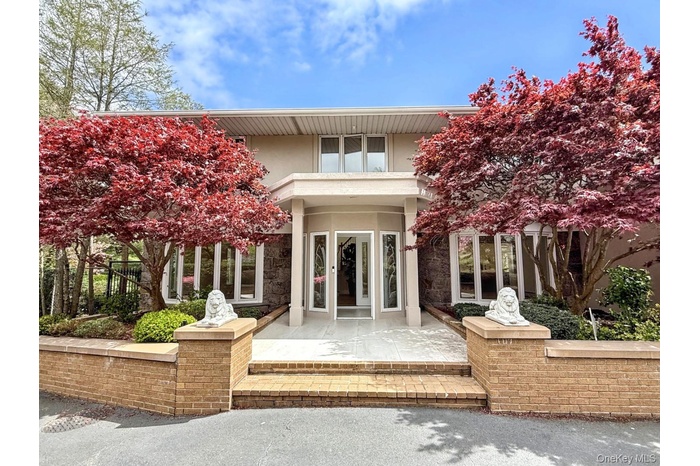 Rear view of house with stucco siding, a patio area, french doors, and a balcony