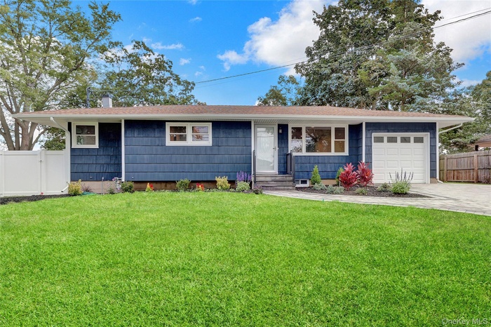 Ranch-style house with an attached garage, driveway, roof with shingles, and a chimney
