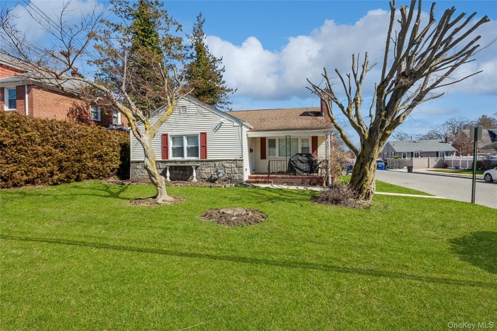 View of front of home featuring a porch, stone siding, and a chimney