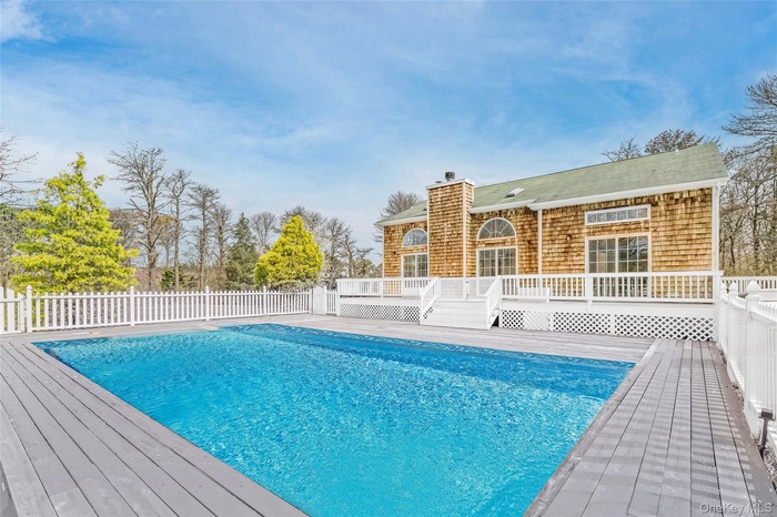 View of pool featuring a wooden deck, a fenced in pool, and fence