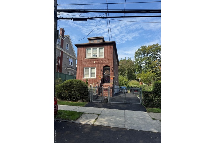 View of front facade with a gate, brick siding, and a fenced front yard