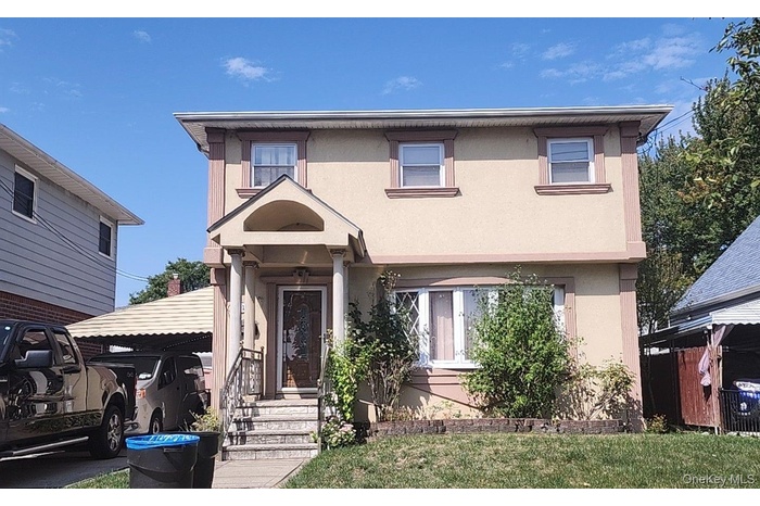 View of front of home featuring stucco siding and a front lawn