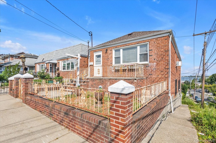 View of front of house featuring brick siding, a fenced front yard, and a residential view