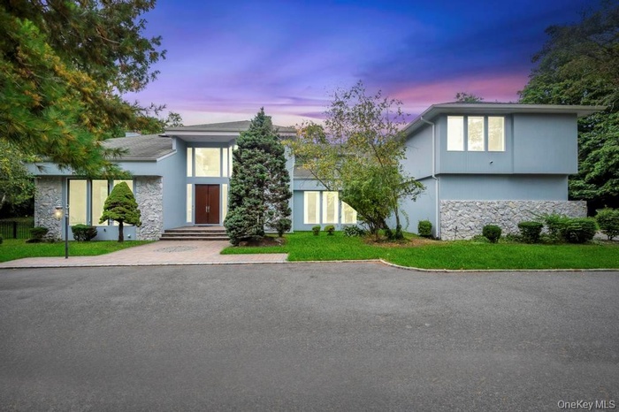 View of front of house with stone siding and a front yard