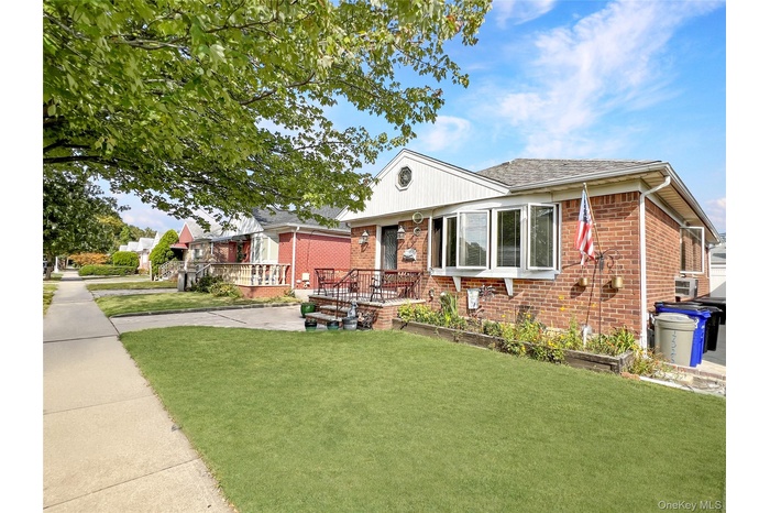View of front of property with a front yard and brick siding