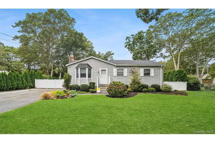 View of front of home with a chimney, driveway, and roof with shingles