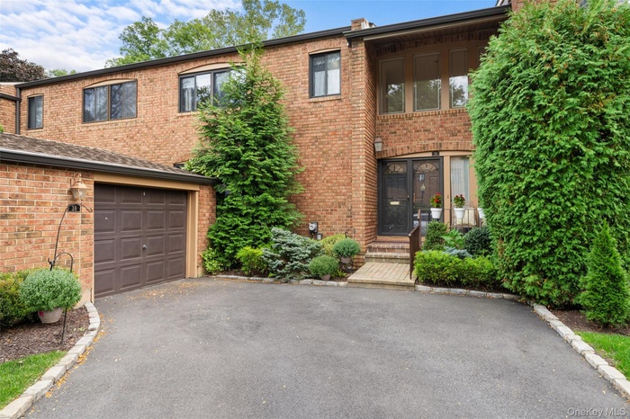 View of front of house with brick siding, asphalt driveway, and a garage