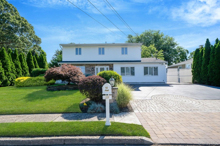 Traditional-style house featuring decorative driveway, a gate, and stone siding