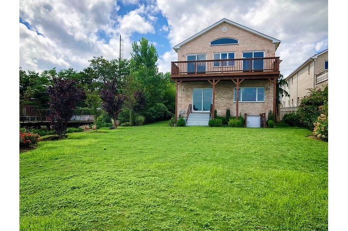 Rear view of house with brick siding and a yard