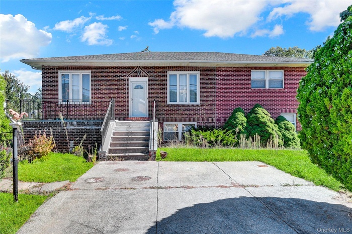 View of front of house with brick siding and a front yard
