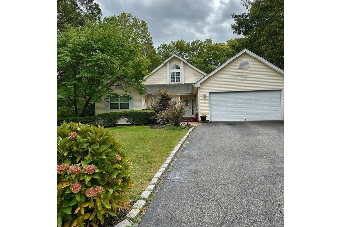 Traditional-style house with driveway and a front lawn