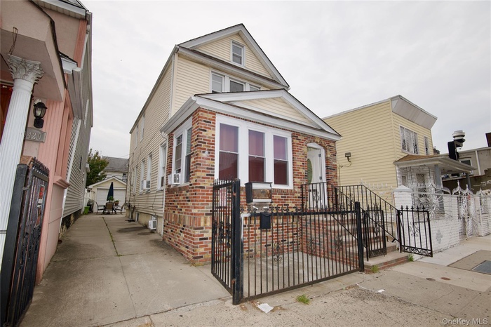 View of front of property with brick siding, a gate, and a fenced front yard