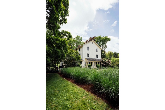 View of side of property featuring a yard and a chimney