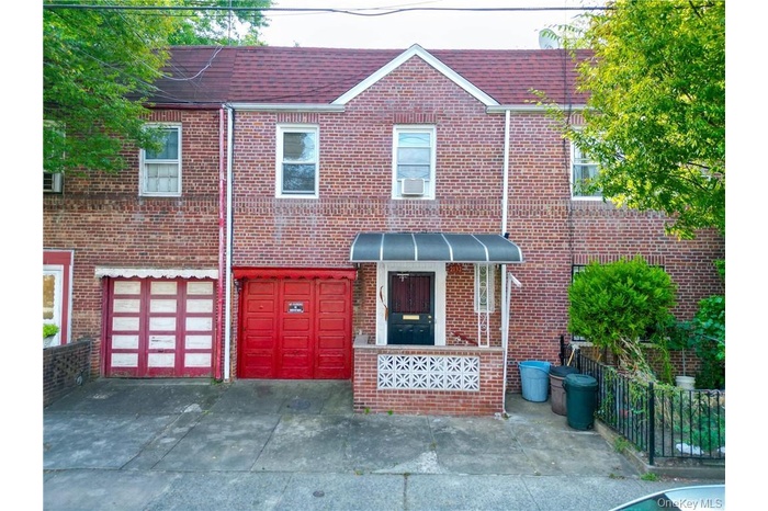 Traditional-style house featuring brick siding, an attached garage, and driveway