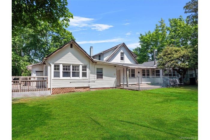 Back of house featuring a wooden deck and a patio area